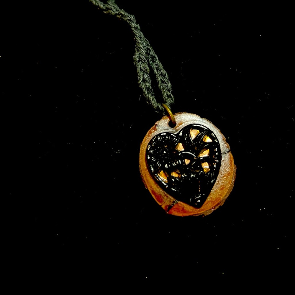 Floral cutout black glass copper backed heart on a wood medallion crochet cord